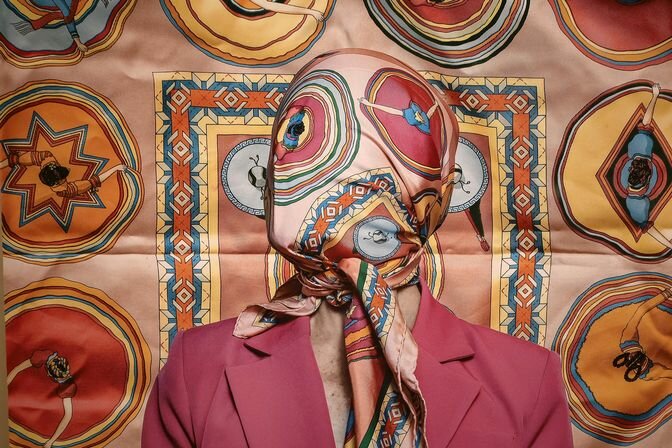 Lara Alcantara Lansberg&rsquo;s &ldquo;Color Cover&rdquo; (2020,) depicts the self-portrait artist with her face tautly cloaked by a vividly colored, silk handkerchief as a euphemism of the pandemic.