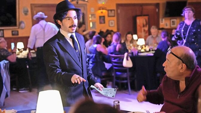 Participants chosen as suspects for the murder mystery dinner will be provided with wearable items to match the role, such as feather boas and lab coats.