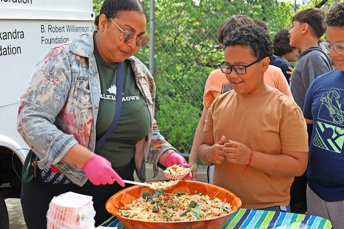 Chef Jamie Rhoden of Harlem Grown serves Lucas, a 5th grader at P.S.207, a portion of orzo pasta salad made in conjunction with Every Kid Healthy Week. .
