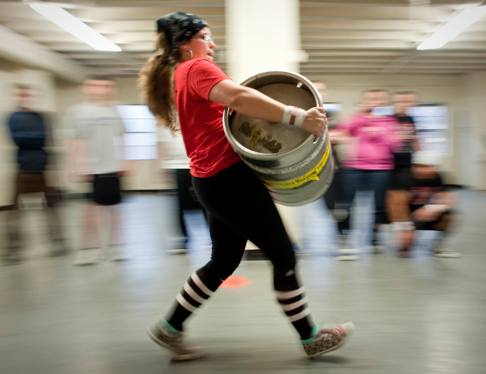 Alexandra Dante carries a 110 lb keg across the gym.
