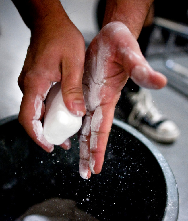 Jay Campo, who won the men's division, applies white chalk to his hands before competing in the farmers hold.