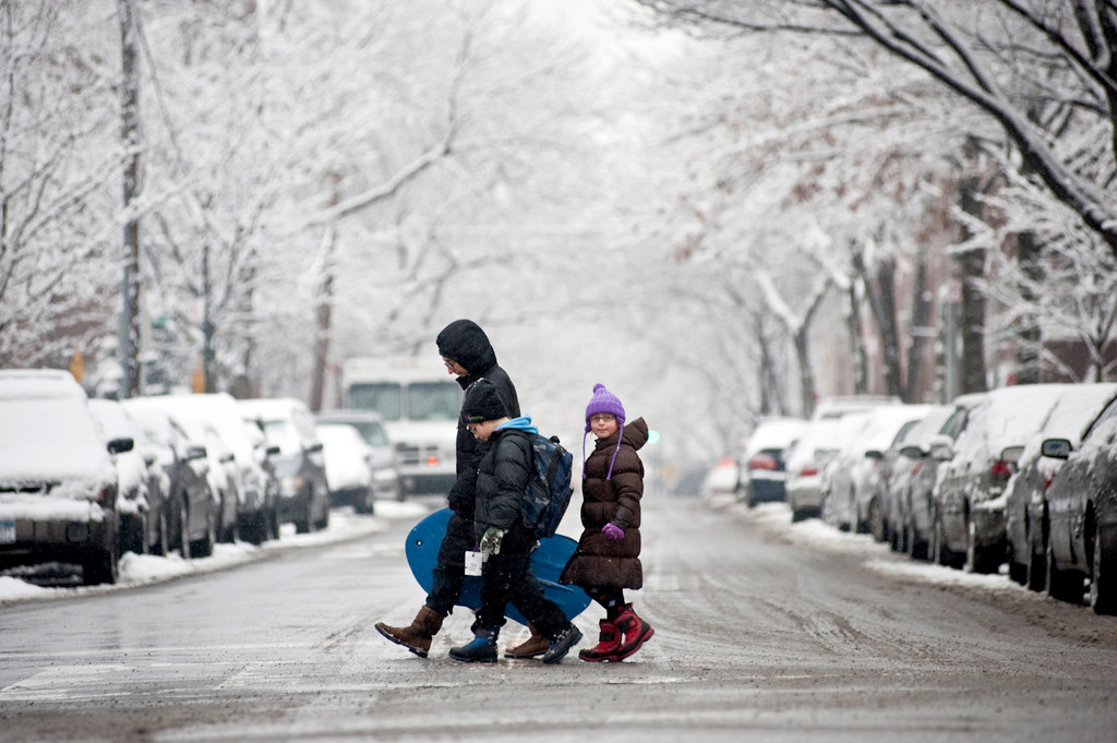 A family walks down Independence Ave., across West 239th St. on Jan. 7.