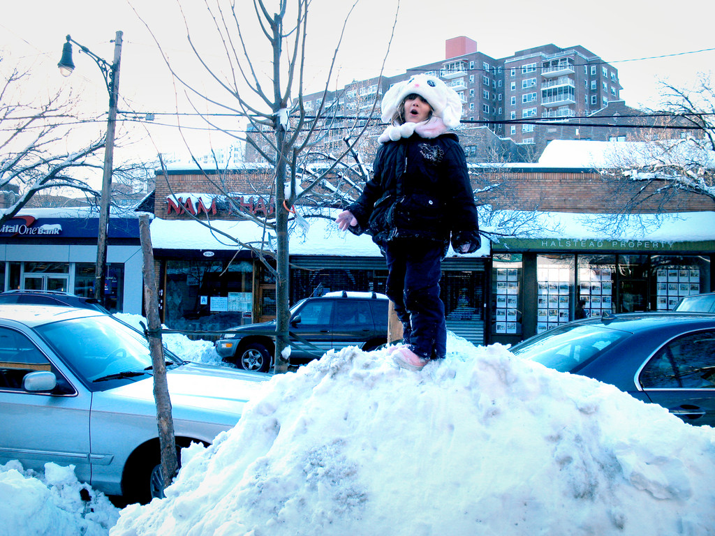 PS24 Kindergardener Kate Murray stands atop a huge snow pile on Johnson Ave. on Jan. 28.
