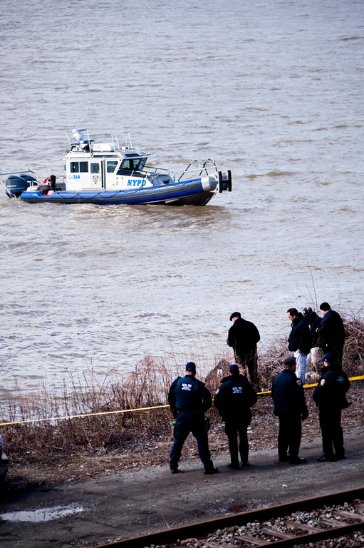 A NYPD boat drifts past emergency personel who survey the condtion of a body found in the hudson river on the afternoon of March 24 Riverdale, south of Riverdale Station.
