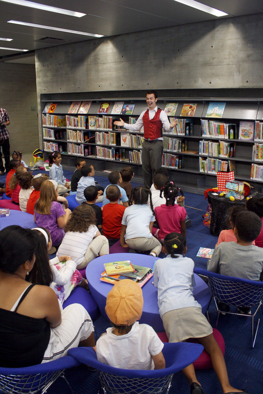 Festivities during the grand opening of the new Kingsbridge Public Library included a show by Magic Evan for a group of young children.