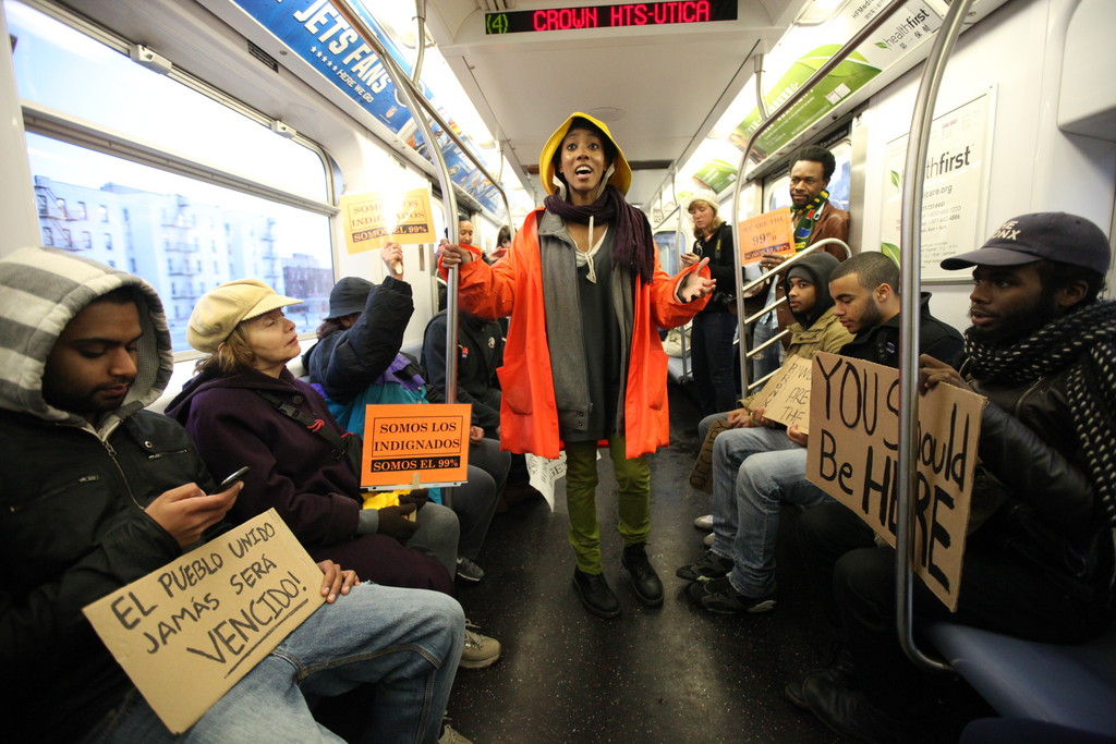 Protest organizer Nicole Carty, center, rallies local protesters with stories and grievances about the state of society in America on the subway from Fordham Road to Foley Park in Manhattan as part of the