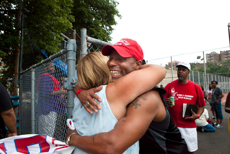 Former assistant football coach Mary Decesare hugs U.S. Army Lt. Col. Derrick Singleton, a former varsity football player.