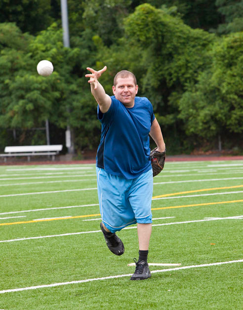 Alumni and former baseball coach Peter Lane practices pitching a softball at the barbecue on Saturday.