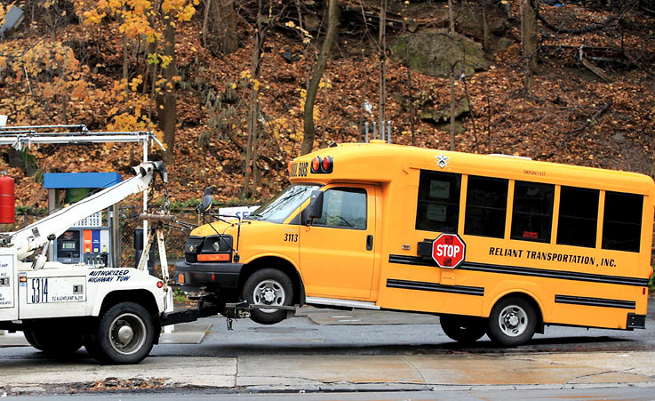 A tow truck pulls away the bus that struck and killed a Riverdale cab driver in December 2011.