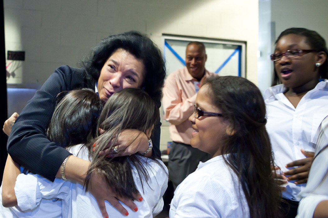 Dolores Peterson, principal of The New School for Leadership and the Arts, hugs students backstage after they sang the national anthem at a Knicks game.