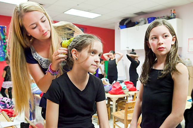 Jessica Lavery,19, works on Sarah Baum, 10, putting every hair in place in the dressing room.