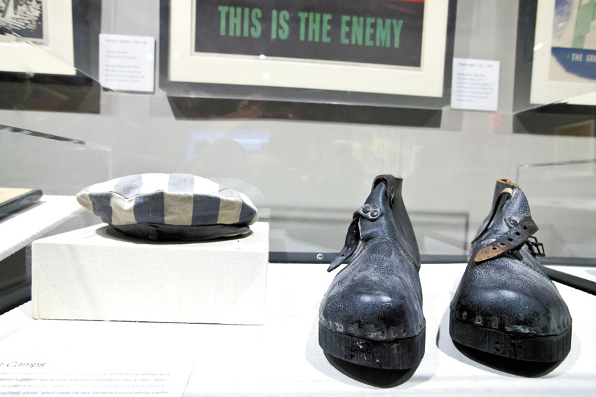 Among a wide variety of artifacts at the museum — including propaganda posters, uniforms and documents — are a striped hat worn by a concentration camp inmate and a pair of wooden-soled leather shoes.