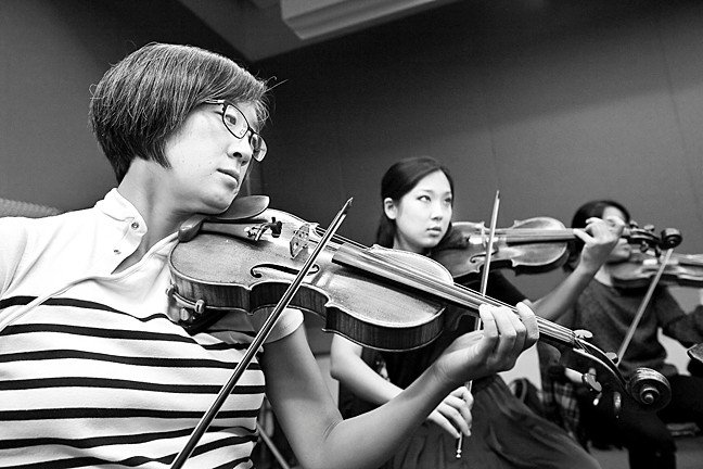 Violinists Salley Koo and Grace Park rehearse.