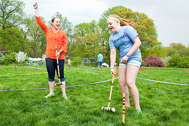 Andria O'Brian, 43, praises her daughter Meghan O’Brian, 12, as she completes a game of crocket on Daffodil Hill at The New York Botanical Gardens as part of the Mother’s Day Weekend Garden Party on Saturday.