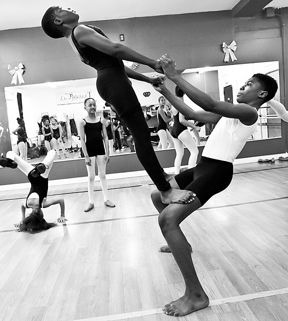 Babou Sanneh, 13, performs a balancing feat with Jaquan Morgan, 14.