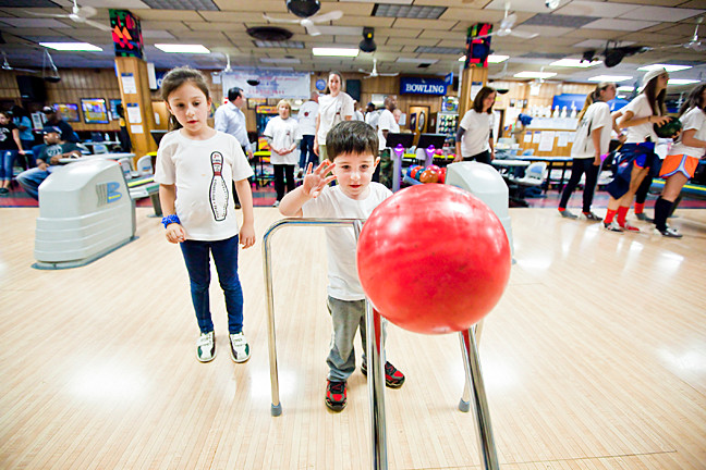 Anna Blanco, 7, watches her brother Alex, 3, take a turn at Bowlerland.