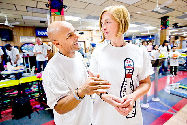 David Corona, 46, gives bowling tips to Board Member Lisa Lindvall, 51.