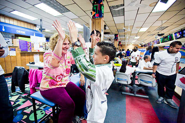 Lori Spector, 70, Deputy Director of Kingsbridge Heights Community Center congratulates Jacob Colón, 10, after his turn at bowling.
