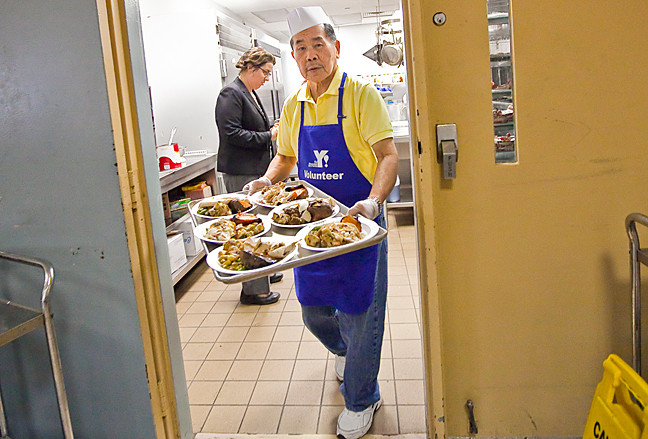 The giving season unofficially begins with Thanksgiving week and volunteers like Duffy Chen, 79, served an early Thanksgiving lunch at The Riverdale Y Senior Center on Tuesday.