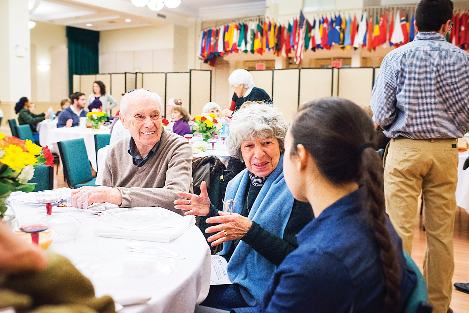 Riverdalian Faye Lieman, in the scarf, talks with students and fellow attendees at the Manhattan College seder celebration 'Bridging Faiths with Yeshiva Chovevei Torah' on Wednesday.