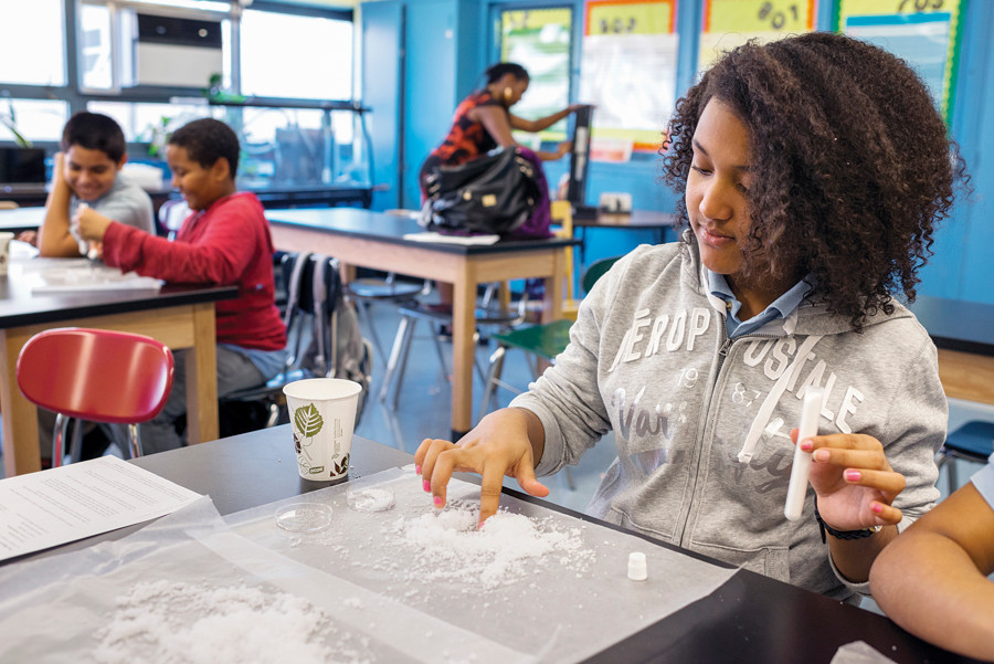 NSLA/M.S. 244 students Yolianna Pimentel and Amy Tejada, both in the 8th grade, examine the properties of salt crystals in an after school science program on Sept. 25.