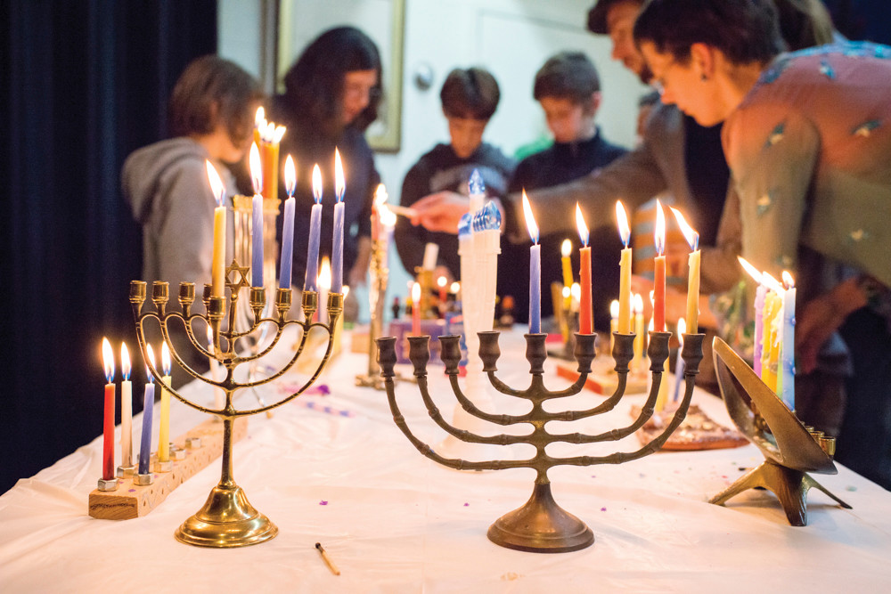 Members of the Society for Ethical Culture light menorah candles during an interfaith gathering in Fieldston on Dec. 9.