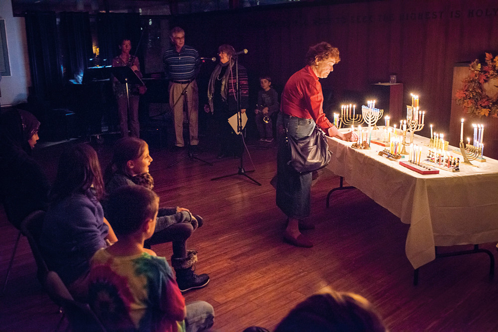 Members of the Society for Ethical Culture light menorah candles during an interfaith gathering in Fieldston on Dec. 9.
