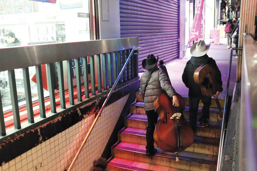 Musicians walk out of the 3rd Avenue-149th Street station, in The Hub.