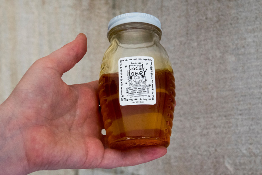 Beekeepers have collected some of the honey the bees have produced, and store it in jars.