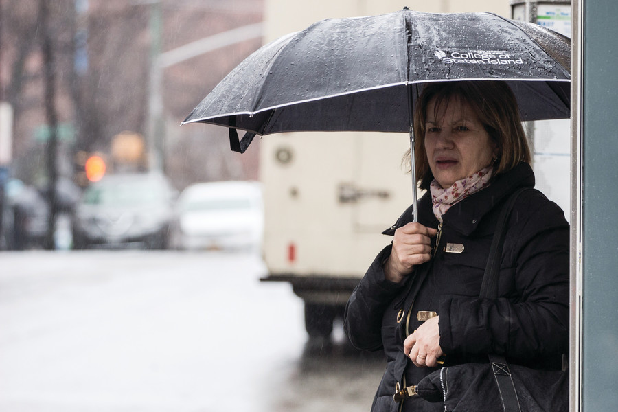 A woman waits in the rain for a bus. Nearly 70 government officials have joined forces to push Gov. Andrew Cuomo to make much-needed improvements to the city’s transit system.