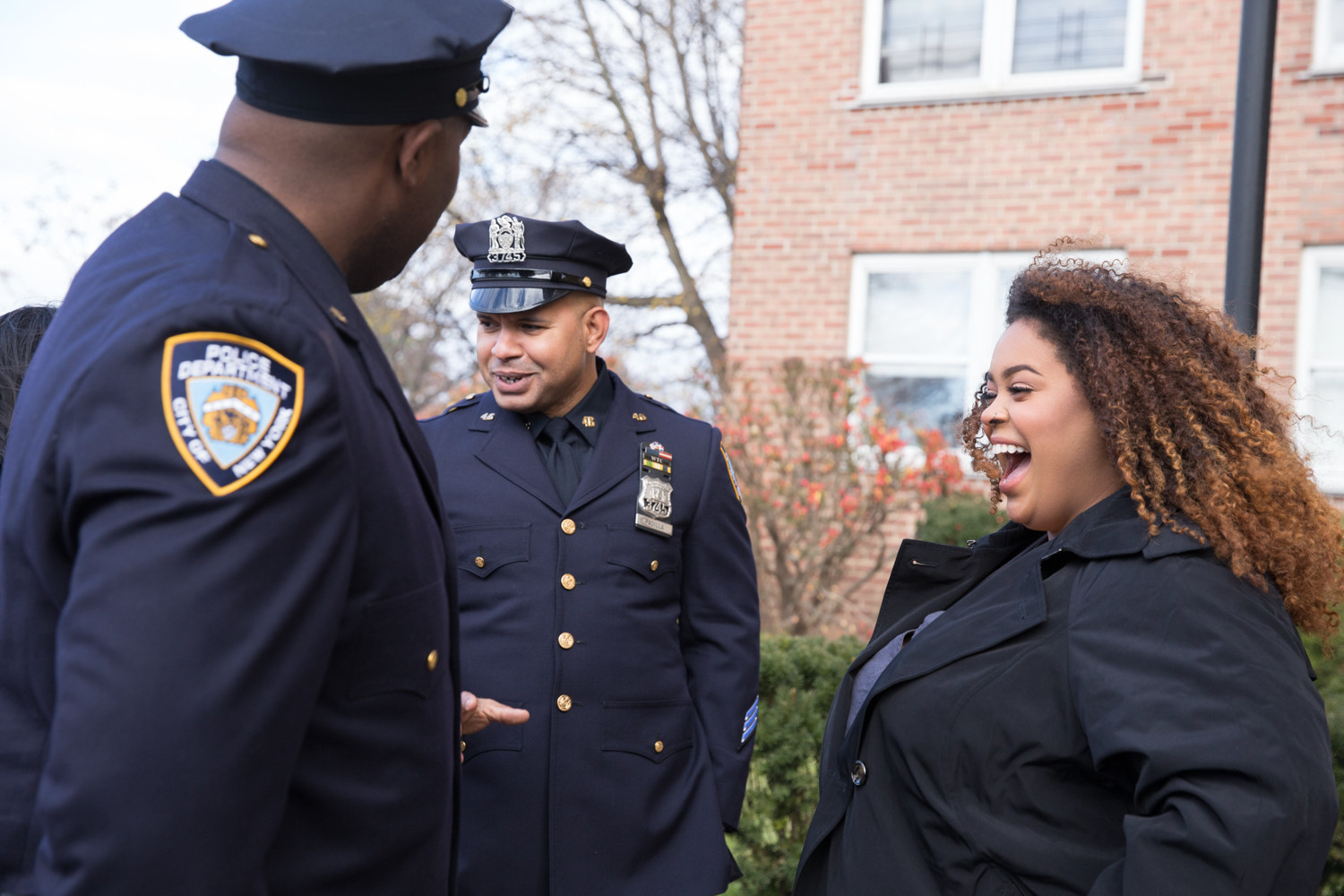 Genesis Villella, the eldest daughter of slain police officer Miosotis Familia, laughs with members of the New York Police Department after a news conference announcing her family’s new home at Skyview-on-the-Hudson.