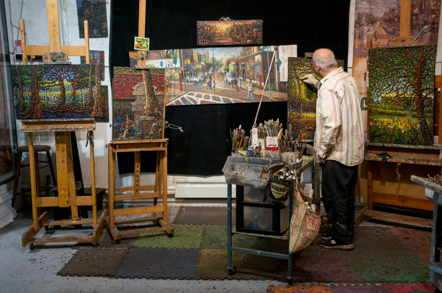 Daniel Hauben works on a painting in his studio. Hauben's paintings are often known for their texture in which figures rise off the canvas creating a three-dimensional effect.