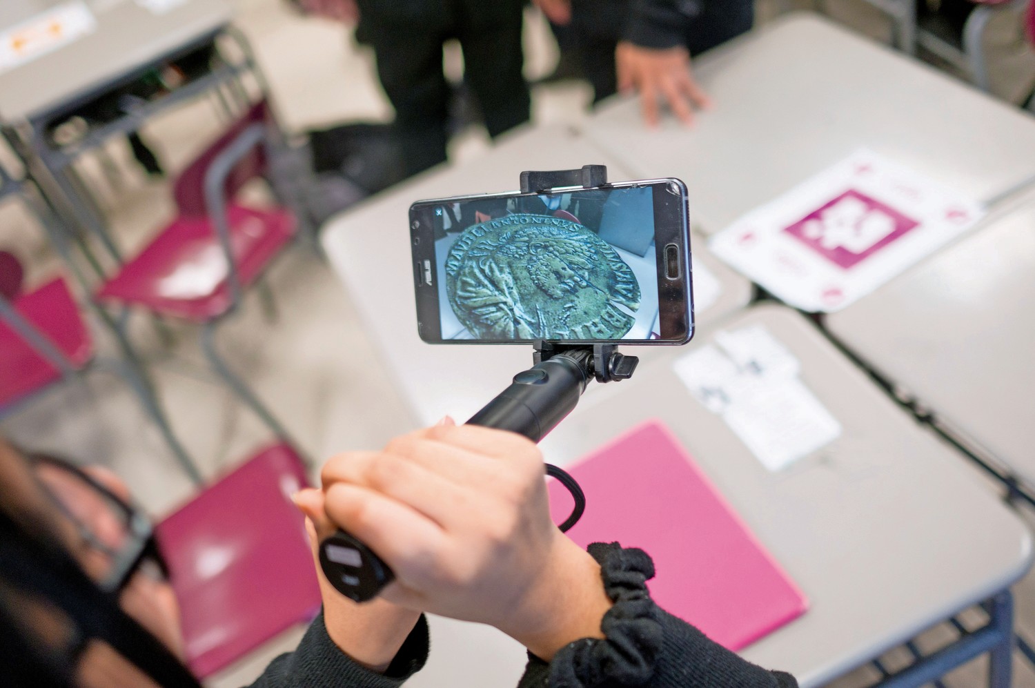 An InTech student looks at an augmented reality version of an ancient Roman coin through Google's app 'Expeditions AR.'