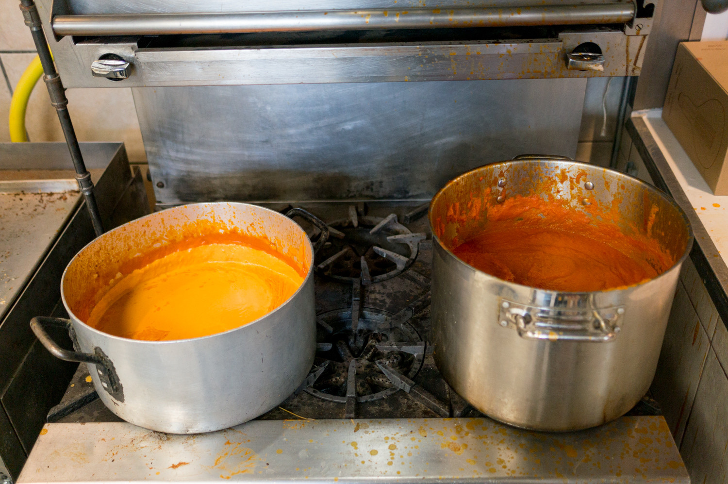 Fresh pots of vodka sauce and tomato sauce sit on the stove in the kitchen of Caffe Buon Gusto near Manhattan, a restaurant that has two other locations in Manhattan and Brooklyn.