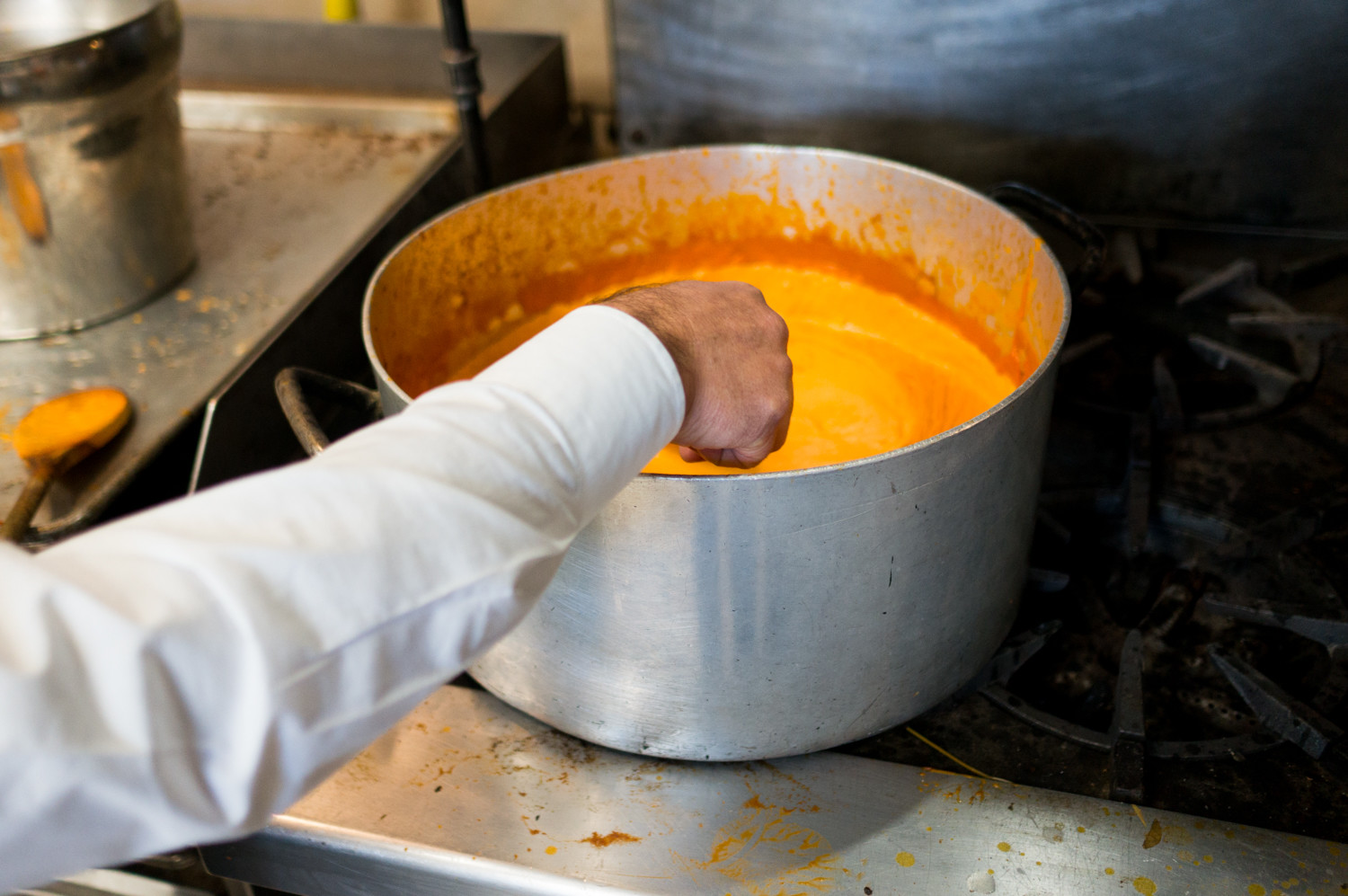 Nando Ghorchian, the owner of Caffe Buon Gusto, stirs a pot of vodka sauce in the kitchen. Ghorchian hopes to provide a space for students and the neighborhood filled with fresh Italian cuisine.