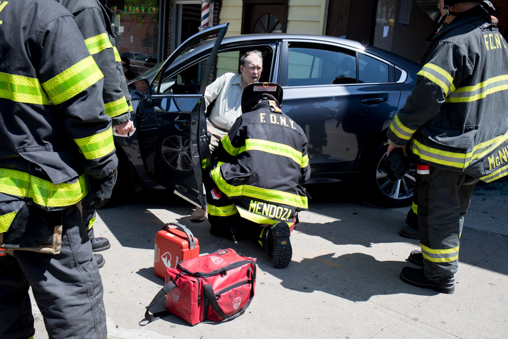 A firefighter helps the 82-year-old driver of a Subaru that crashed into the Kumon Math and Reading Center's North Riverdale location around lunchtime May 9. The man, whose name hadn’t been released as of last Monday, reportedly thought he had his foot on the break, but actually had it on the accelerator, police said, reversing his car straight into the storefront.