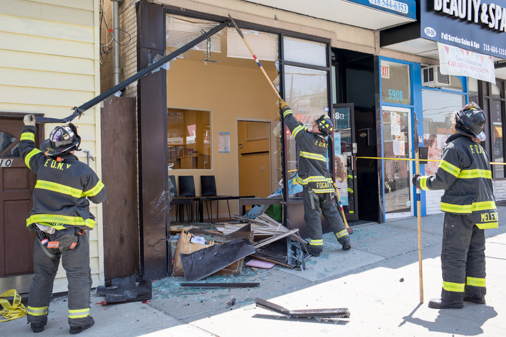 Firefighters clear debris from where a car rammed into the Kumon Math and Reading Center's North Riverdale location around lunchtime May 9. Instructor Claire Kim, who runs the center, said she canceled a class for safety the day after the collision, but held a makeup session the following Saturday.