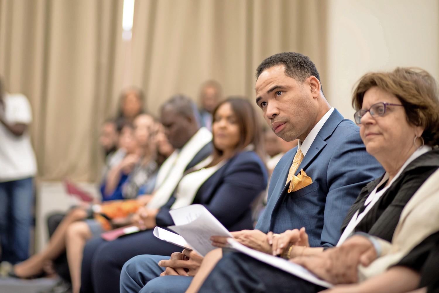 Lawrence Fauntleroy, a graduating student at Lehman College, listens as he is introduced at the school's first induction ceremony for adult degree program students into the national honor society, Upsilon Sigma of Alpha Sigma Lambda.