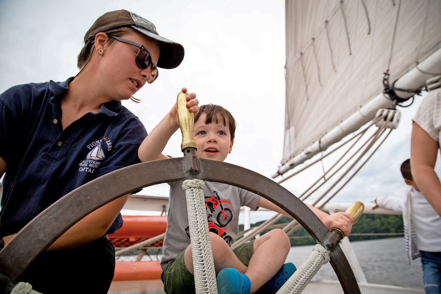 Captain Fern Hoffmann shares the steering wheel with Aaron Fitzsimmons aboard the Pioneer schooner during RiverFestBX.