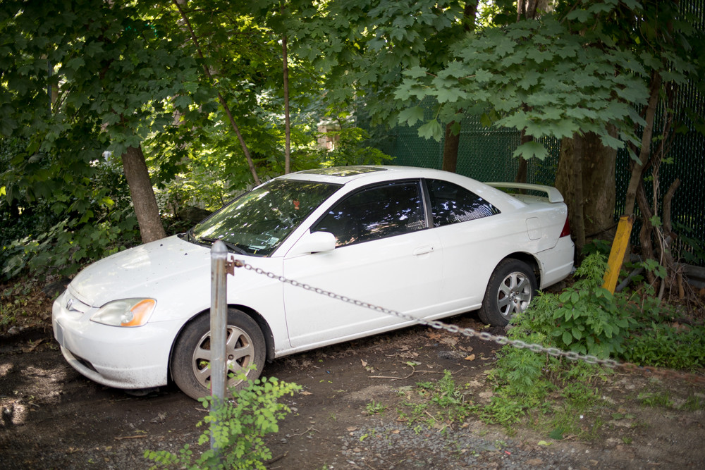 An abandoned car sits on West 237th Street between Henry Hudson Parkway West and Independence Avenue. Marlene Minarik has noticed more abandoned cars filling the streets of her neighborhood in recent years. ‘It’s just unsightly,’ the Riverdale resident said. ‘Some of them are really beat-up.’