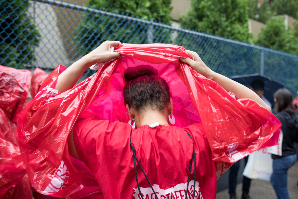 A protester puts on a poncho at a rally outside Allen Hospital just off Broadway on June 13. The New York State Nurses Association organized the rally over New York-Presbyterian’s plan to decertify 30 beds in the psychiatric ward.