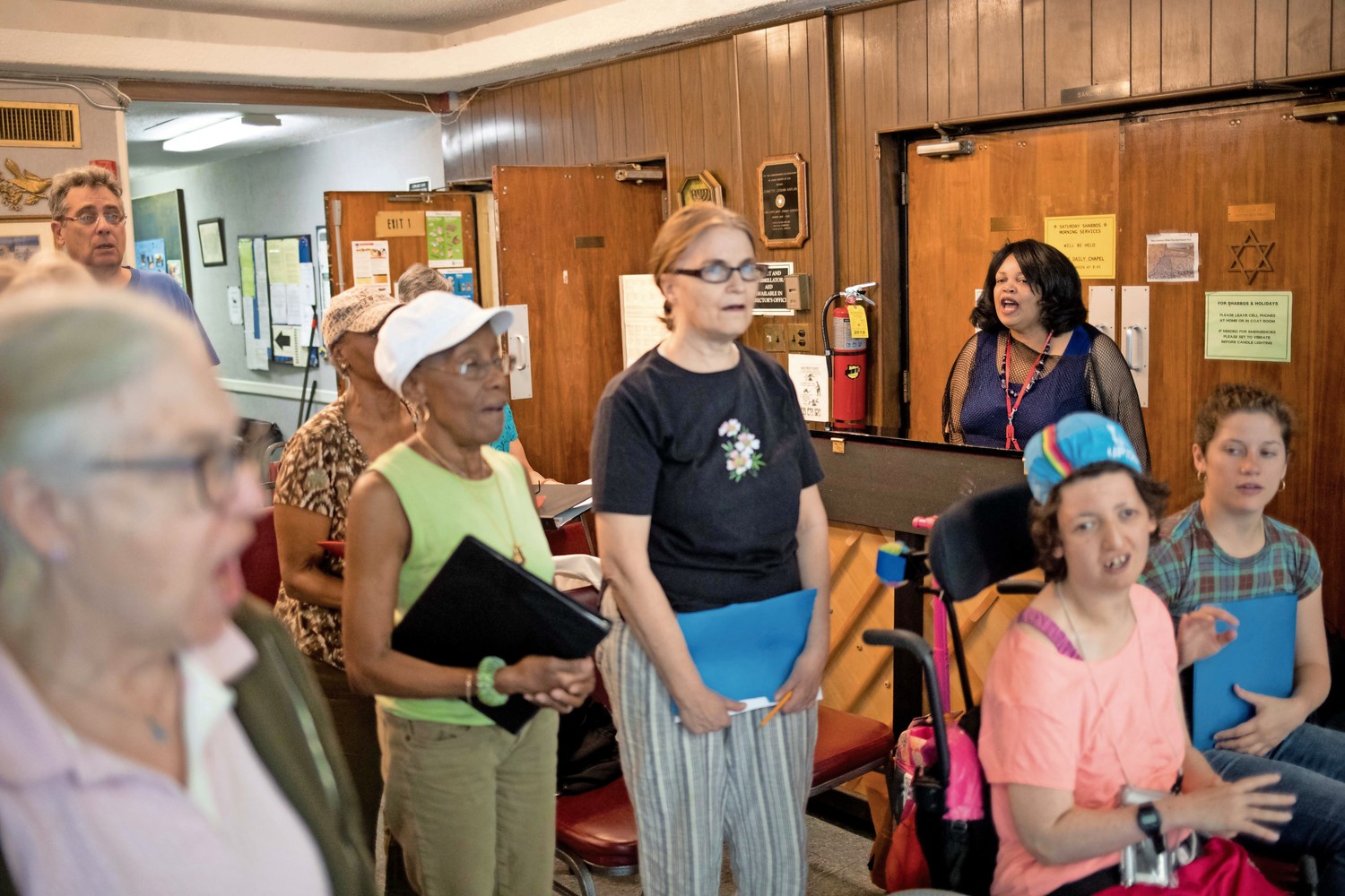 Cheryl Warfield leads singers through vocal exercises during a rehearsal at the JASA Van Cortlandt Senior Center. Warfield has been teaching senior citizens at the center how to sing for an upcoming performance on Independence Day.
