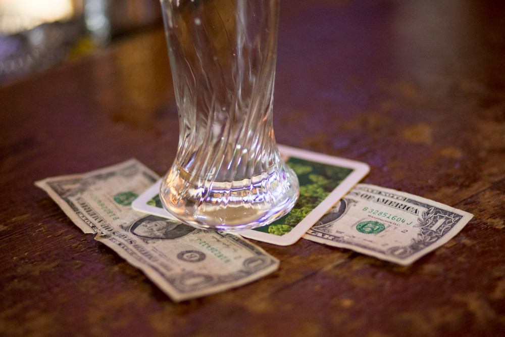 A $2 tip rests under an empty glass at the Bronx Ale House in Kingsbridge. Owner James Langstine supports the state’s tipped wage credit — which allows restaurants to pay tipped employees less than the minimum wage as long as their tips make up the difference. That’s because, he says, it benefits servers, bartenders, customers, and establishments like his own.