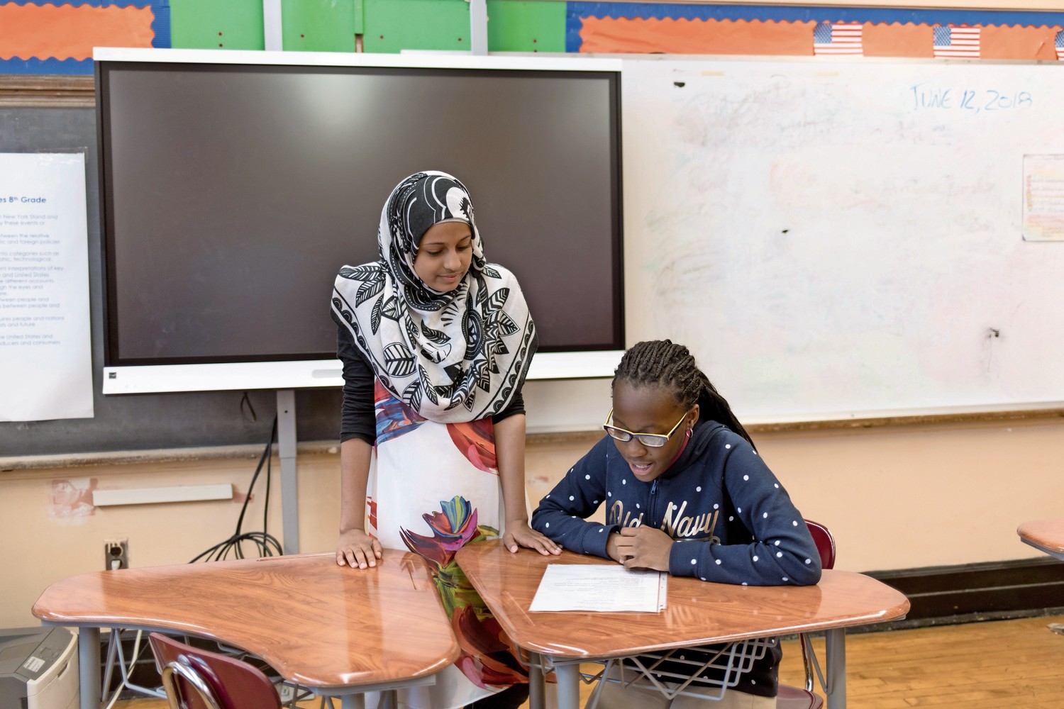 Reem Othman, left, asks Hailey Gyameral to read a portion of a document obtained in evidence during a practice run of a mock trial at P.S. 95. Students there will compete in the Thurgood Marshall Mock Trial Competition.