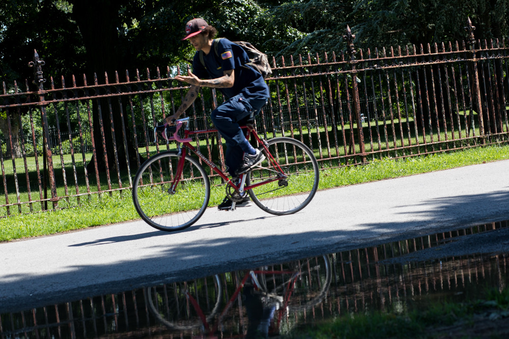 A cyclist rides along the fence surrounding the Van Cortlandt House Museum. The fence suffers from rust damage and desperately needs a paint job. But repairing it could be a multimillion-dollar project, Friends of Van Cortlandt Park executive director Christina Taylor says.
