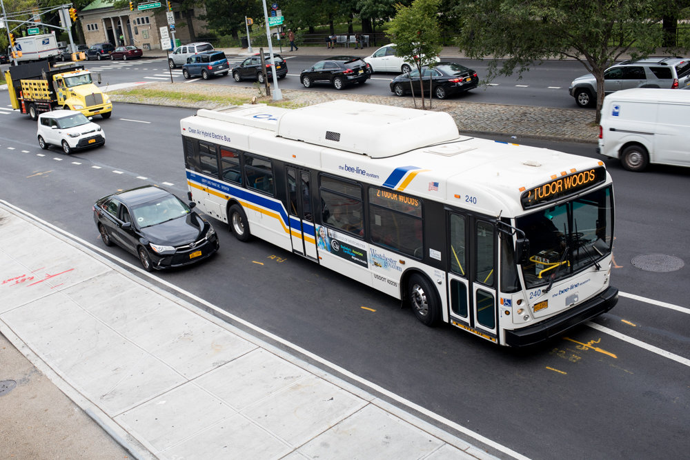 A Bee-Line bus from Westchester County navigates around a stopped car at a bus bulb located on the southbound side of Broadway near West 242nd Street. Nearby merchants have complained about the traffic problems this newly installed bulb causes.