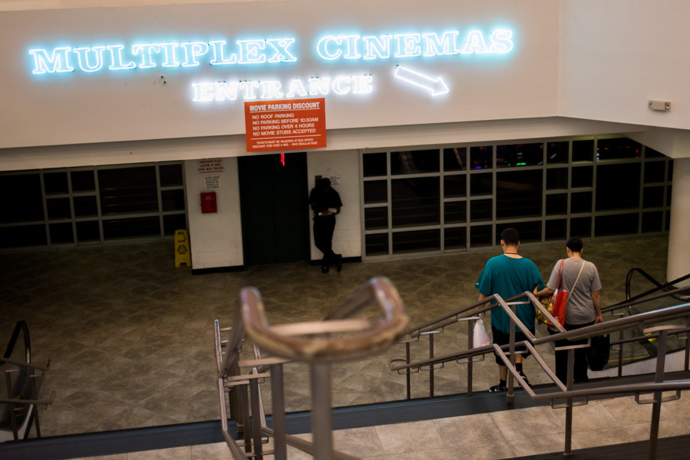 People head downstairs to the movies at Concourse Plaza Multiplex Cinemas near Yankee Stadium, one of only two movie theaters in the Bronx.