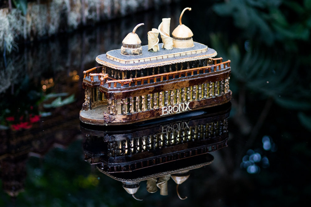 A replica of an early 20th century Bronx ferry floats on the water in the final display of the New York Botanical Garden's Holiday Train Show.