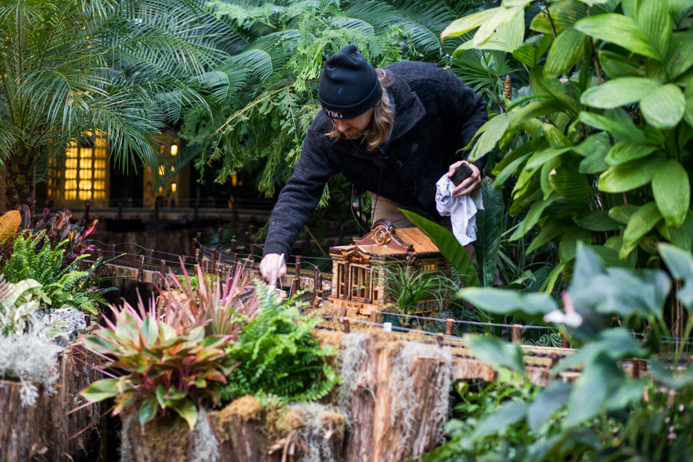 Brandon Munger does light maintenance work on a display in the New York Botanical Garden's Holiday Train Show.