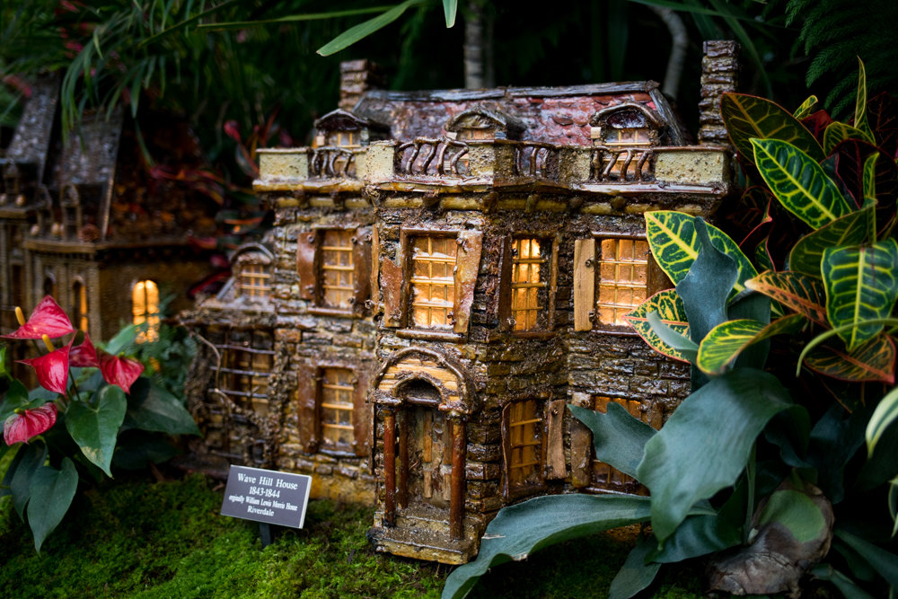 A replica of Wave Hill House is nestled among foliage in the Holiday Train Show at the New York Botanical Garden.